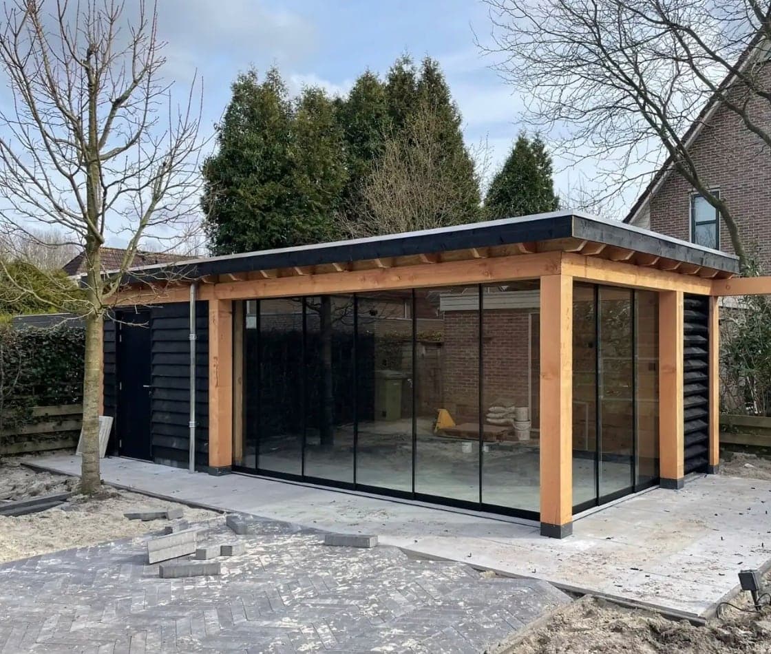 Glazen veranda met houten frame en schuifwanden in de tuin